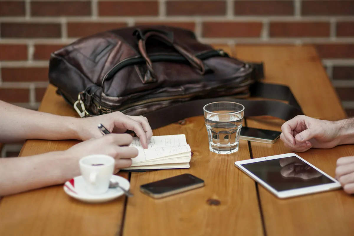 A client and attorney meeting over coffee and notes