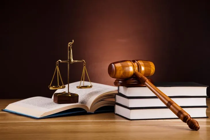 A gavel and scales of justice on a stack of law books