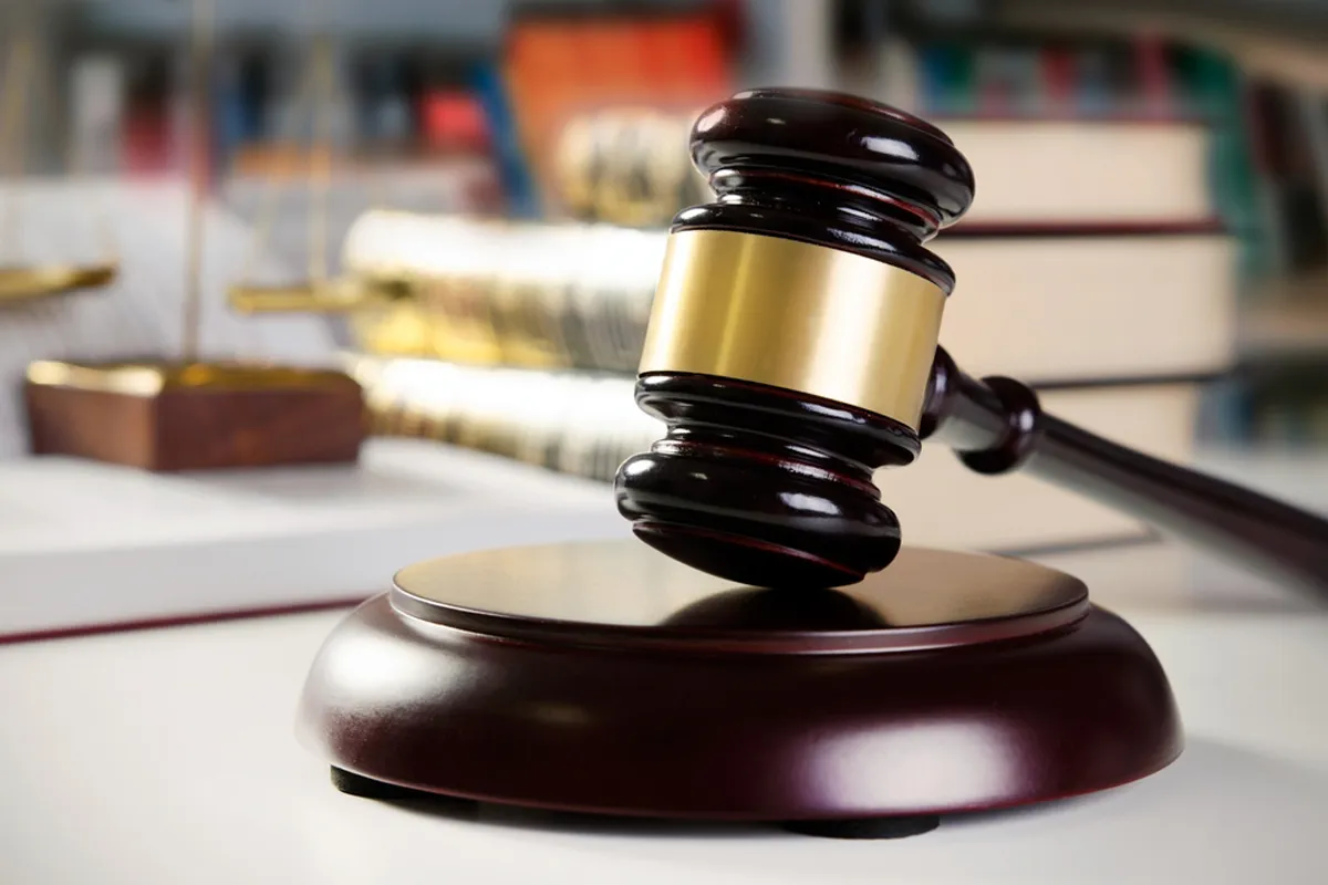 A wooden gavel with a brass band on a desk